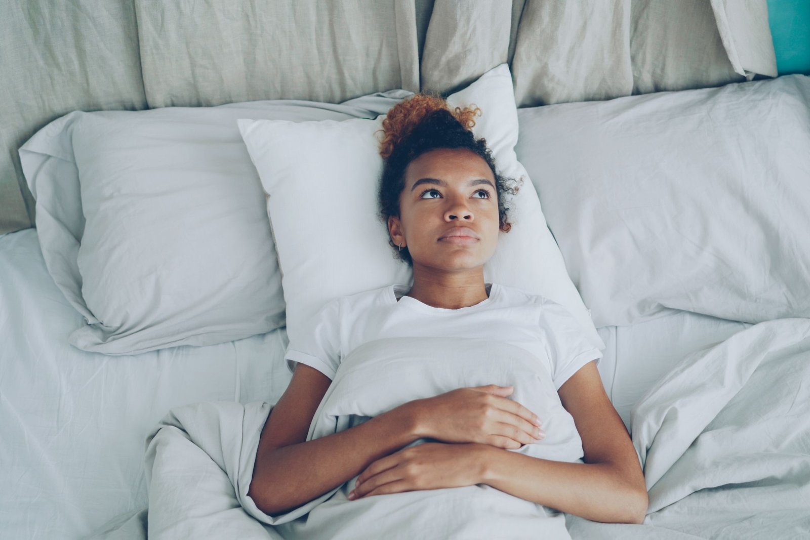 Personne allongée dans un lit, les yeux ouverts, figée au réveil, illustration douce sur fond bleu nuit